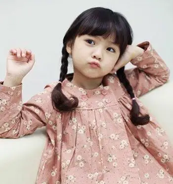 小女孩时尚扎发发型设计自然色的柔顺发丝在两侧编织成精致的麻花辫